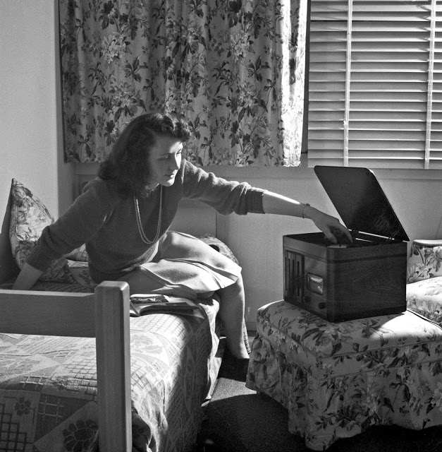 A girl in her room playing a phonograph at Arlington Farms, 1943.